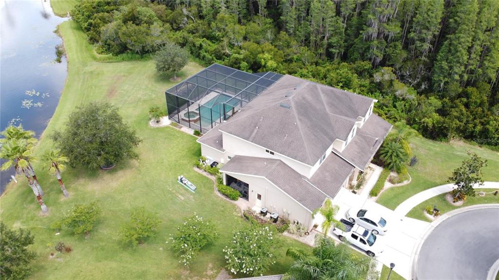An aerial view shows a two-story house with a screened pool and a large yard — 10503 PALM COVE AVENUE, TAMPA, FL