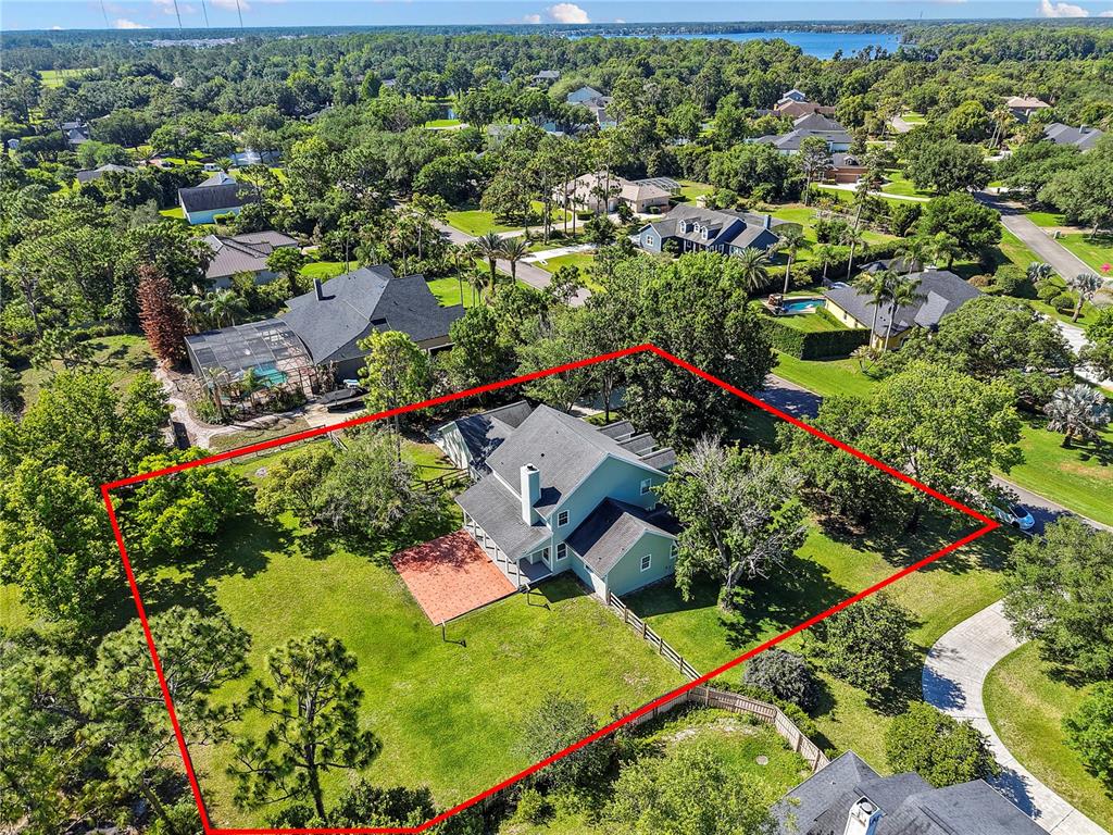An aerial view shows a two-story house with a red brick patio and large yard — 761 N BELFAST PLACE, CHULUOTA, FL
