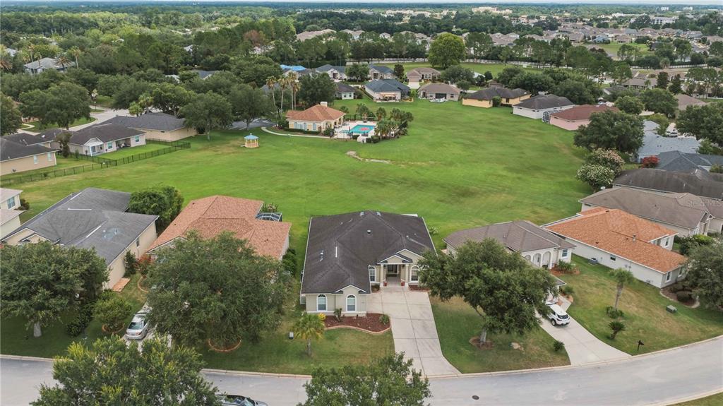 An aerial view shows a suburban neighborhood with a large central grassy field — 5030 SW 63RD LOOP, OCALA, FL