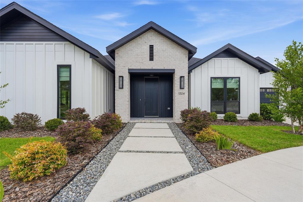 A spacious living and dining area features light wood floors, large windows, and modern decor — 1324 SW 120TH DRIVE, GAINESVILLE, FL