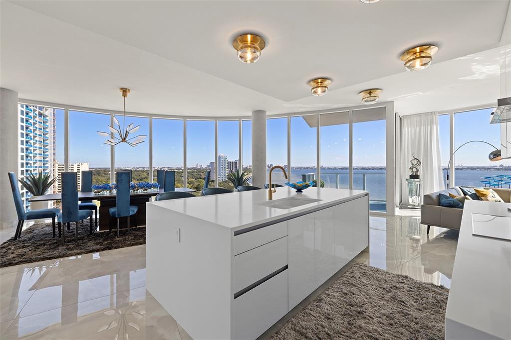 A modern open-concept kitchen and dining area features a large white island and floor-to-ceiling windows — 2900 W BAY TO BAY BOULEVARD UNIT 1403, TAMPA, FL