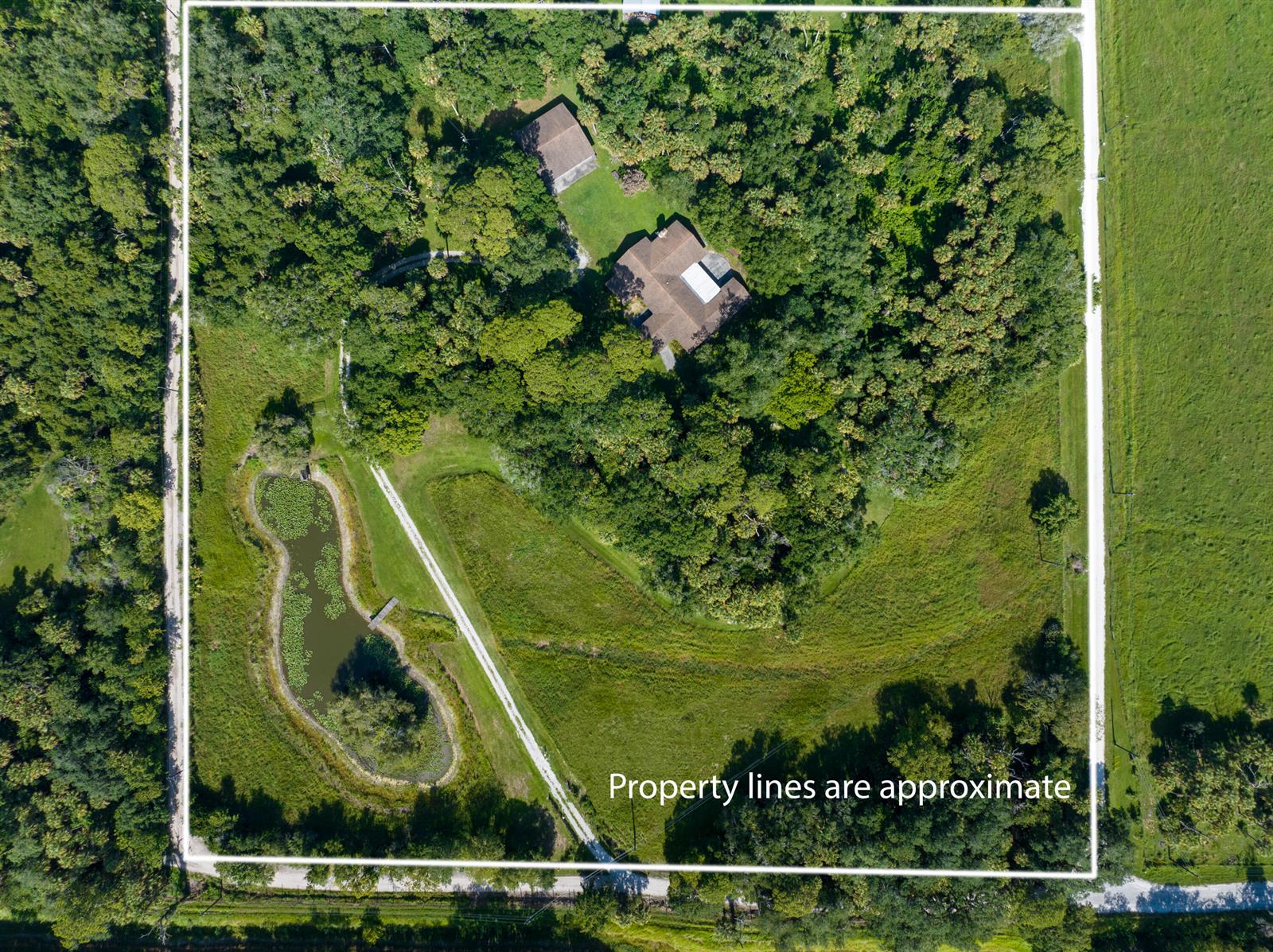 An aerial view shows a house and outbuilding surrounded by trees, pasture, and a pond — 13500 NW 2nd Avenue, Okeechobee FL 34972, OKEECHOBEE, FL