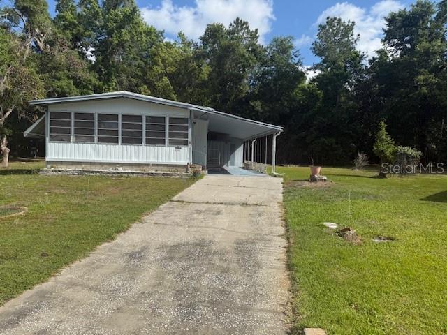 A single-story mobile home with a screened-in porch and a concrete driveway — 7256 WINDY WAY, BROOKSVILLE, FL