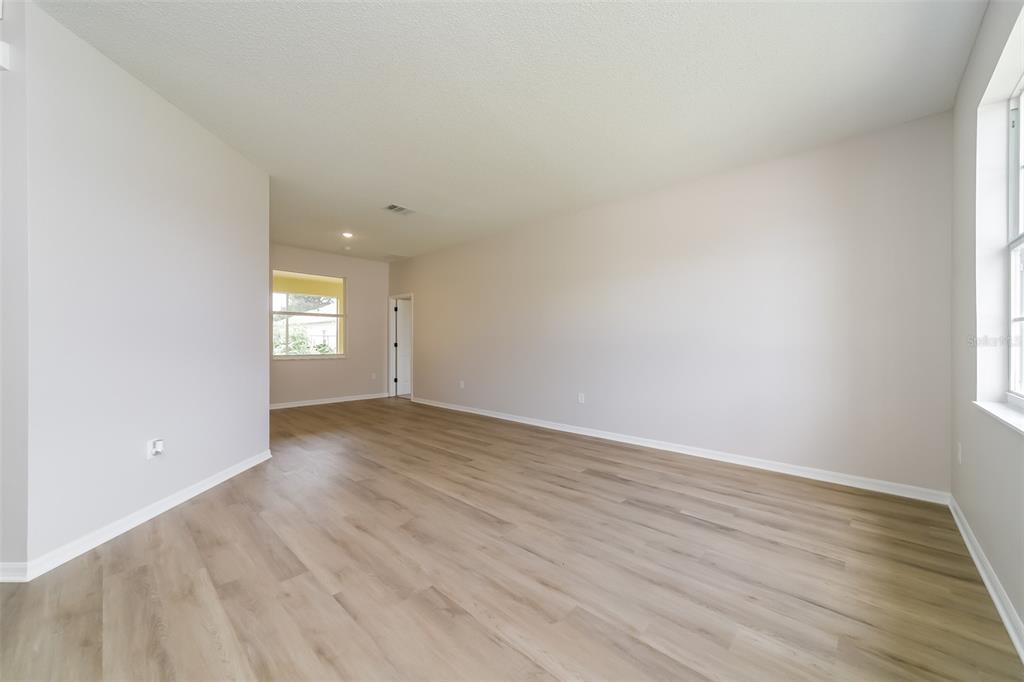 An empty room with light-colored walls, wood-look flooring, and a window — 539 BRENTFORD COURT, KISSIMMEE, FL
