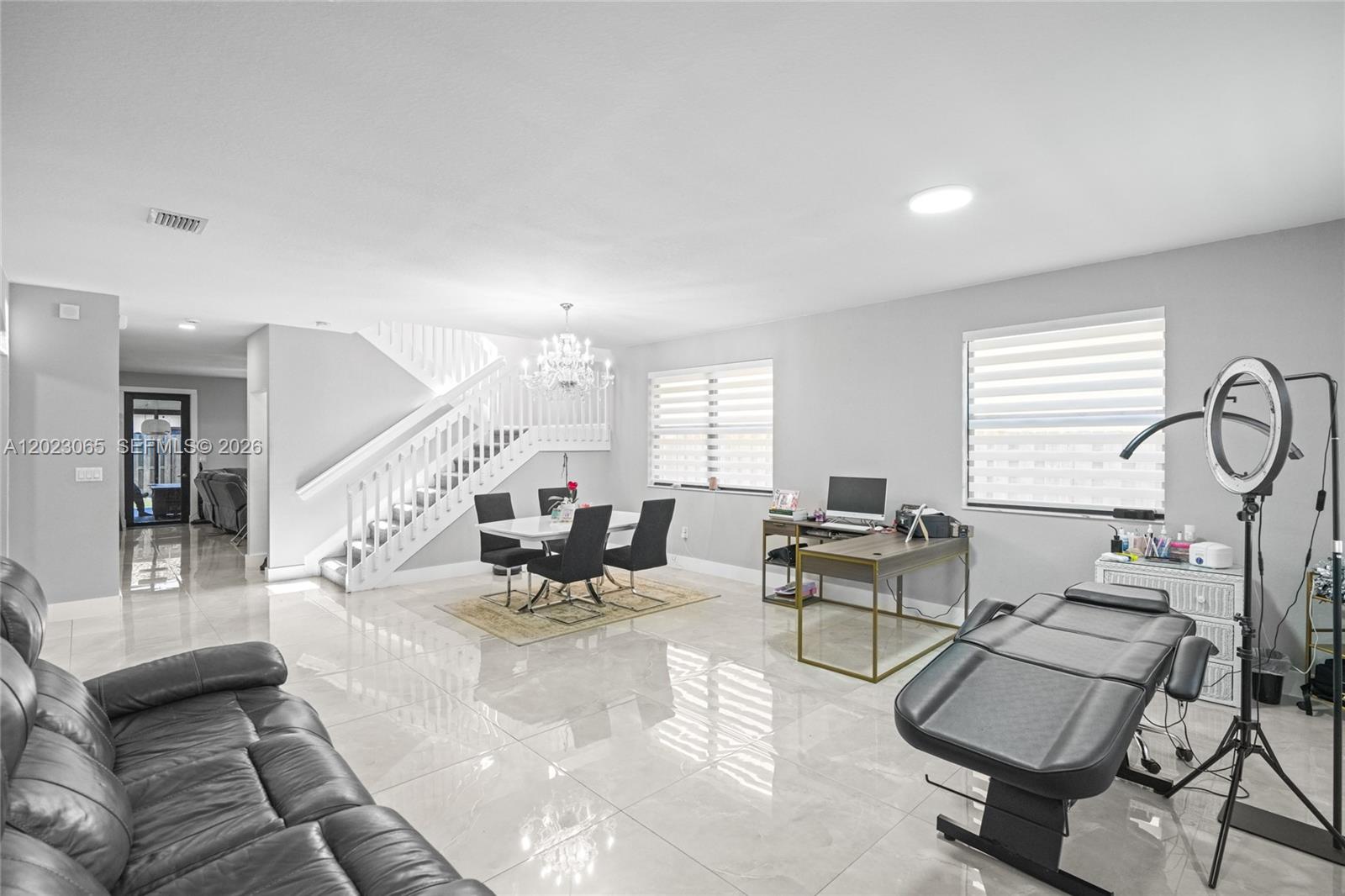 A spacious room features white tile floors, a dining area, a desk, and a massage table — 11711 SW 234th St, Homestead FL 33032, HOMESTEAD, FL