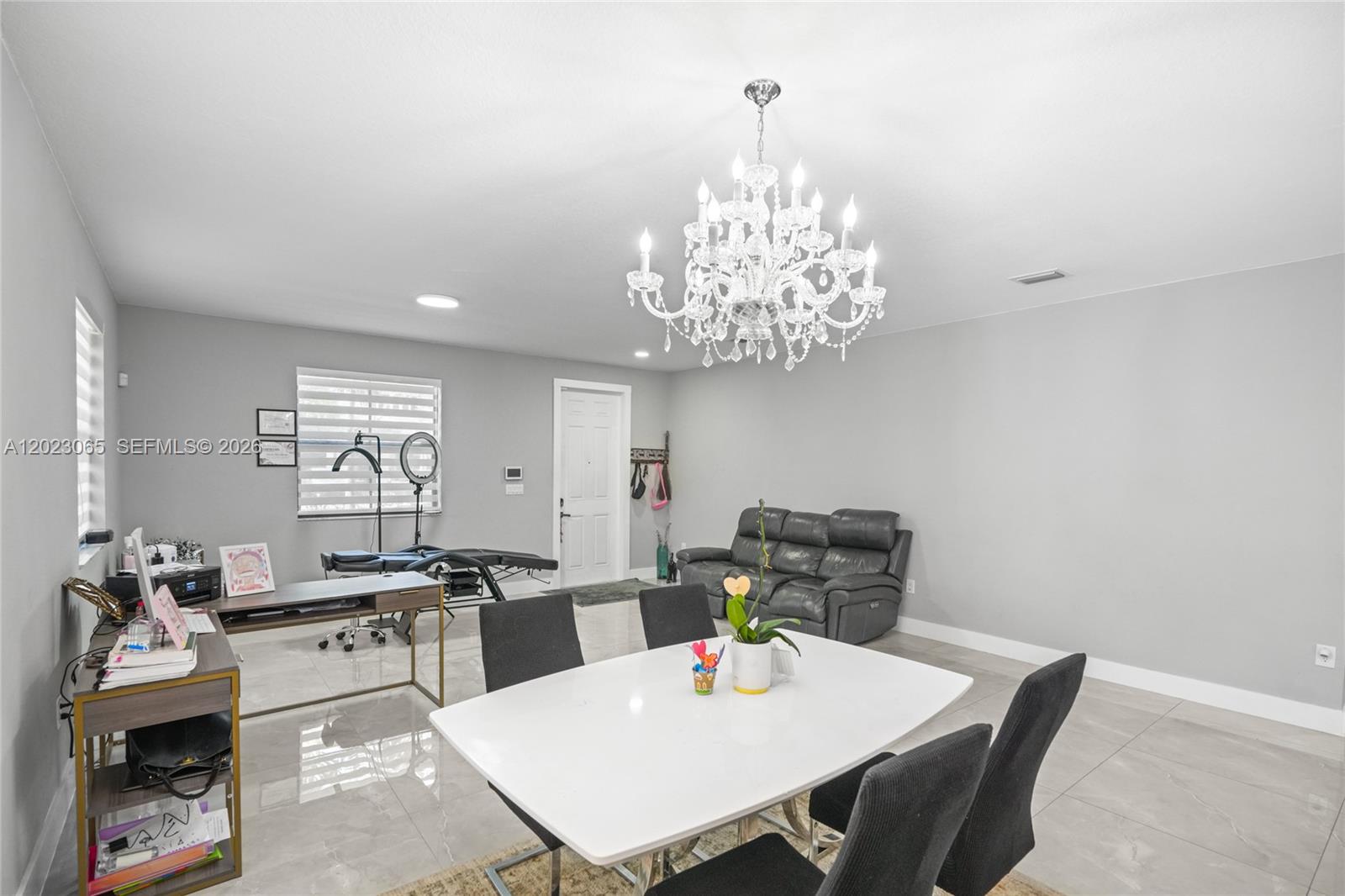 A multi-purpose room features a dining table, a desk, a treatment bed, and a chandelier — 11711 SW 234th St, Homestead FL 33032, HOMESTEAD, FL
