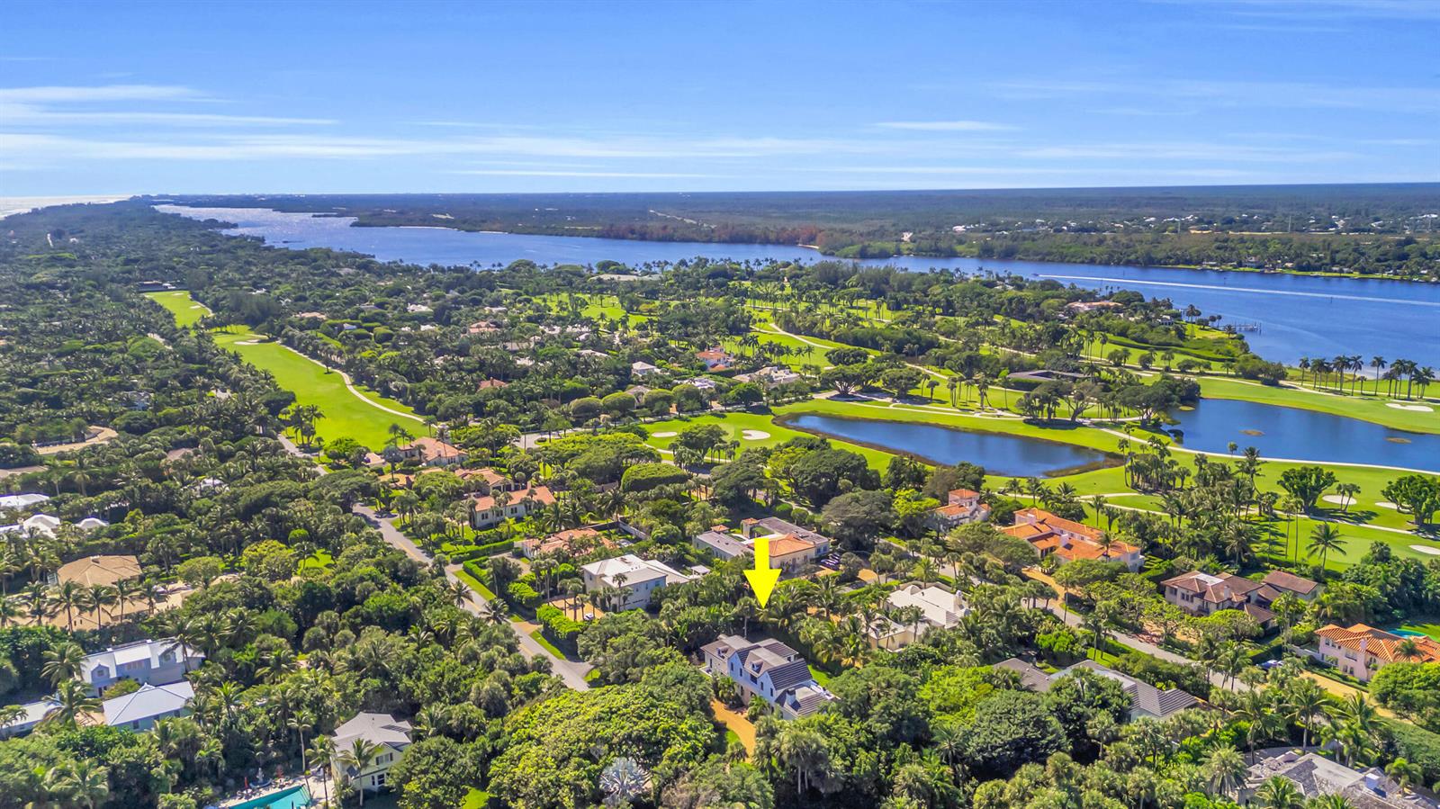 An aerial view shows a residential neighborhood with lush trees, a golf course, and water — 44 S Beach Road, Jupiter Island FL 33455, JUPITER ISLAND, FL