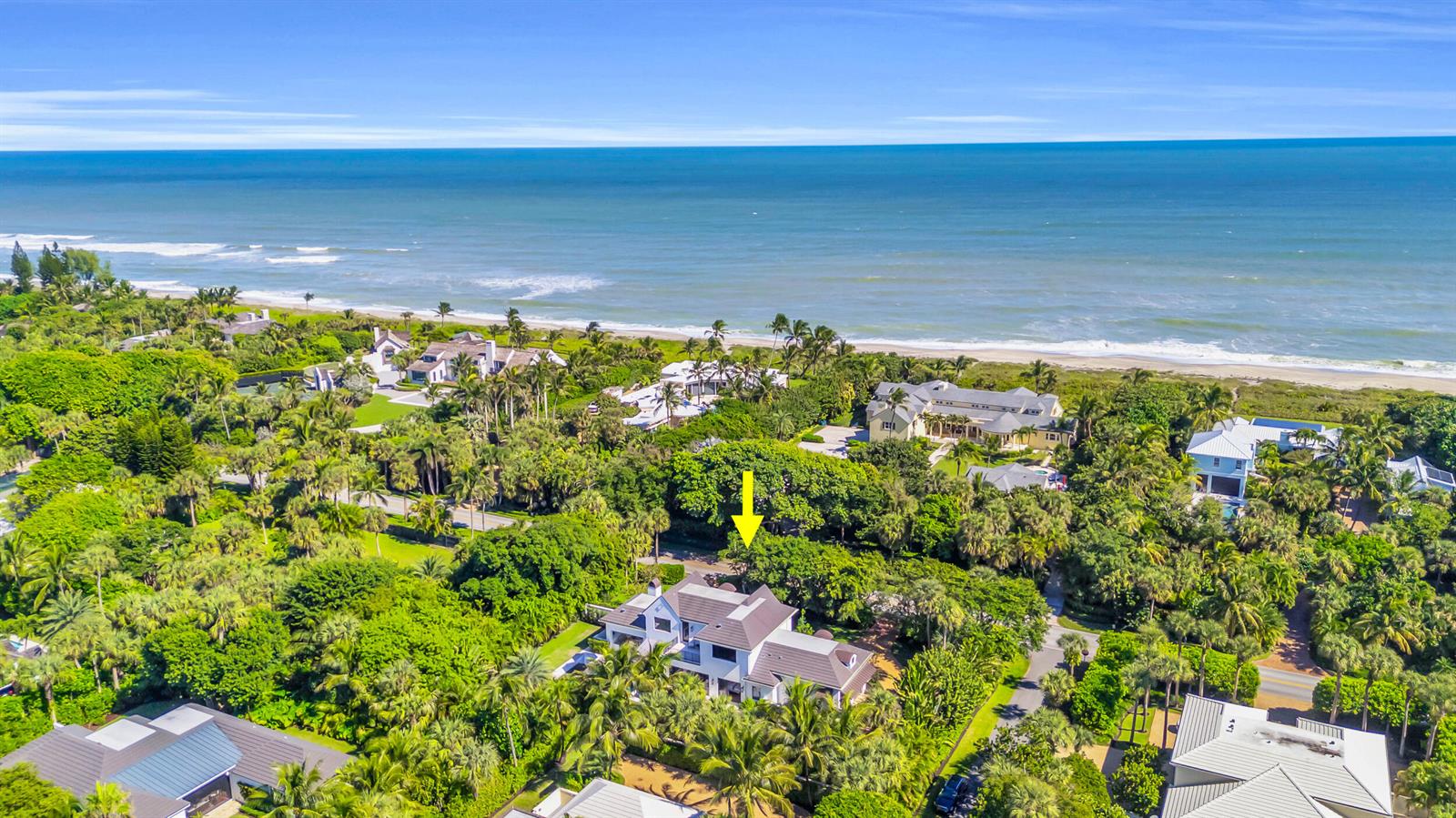 An aerial view shows a large house surrounded by lush trees near the ocean — 44 S Beach Road, Jupiter Island FL 33455, JUPITER ISLAND, FL