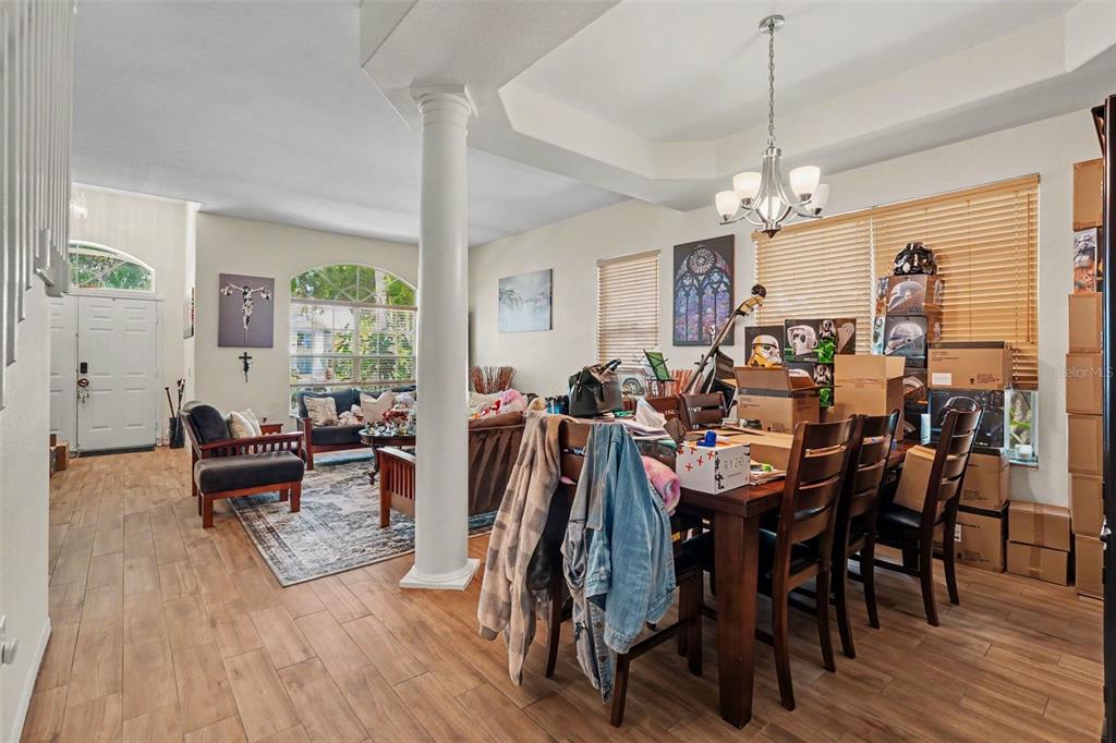 A dining area with a wooden table and chairs sits adjacent to a living room — 7212 HAMMET ROAD, TAMPA, FL