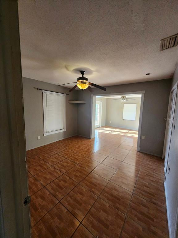 An interior view of a living area with tile flooring, a ceiling fan, and an opening — 2220 BIRCHCREST BOULEVARD, PORT CHARLOTTE, FL