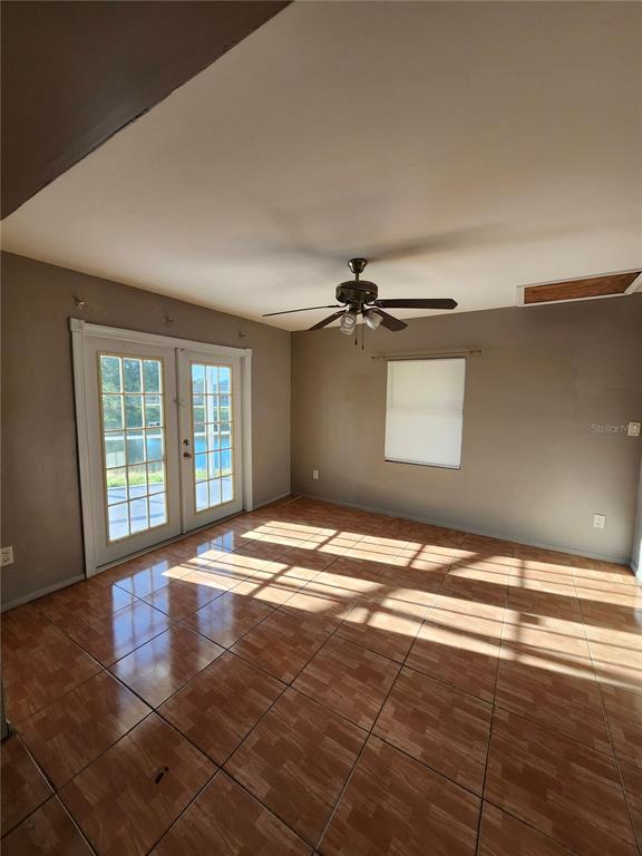 A room with brown tile flooring, a ceiling fan, and French doors leading outdoors — 2220 BIRCHCREST BOULEVARD, PORT CHARLOTTE, FL