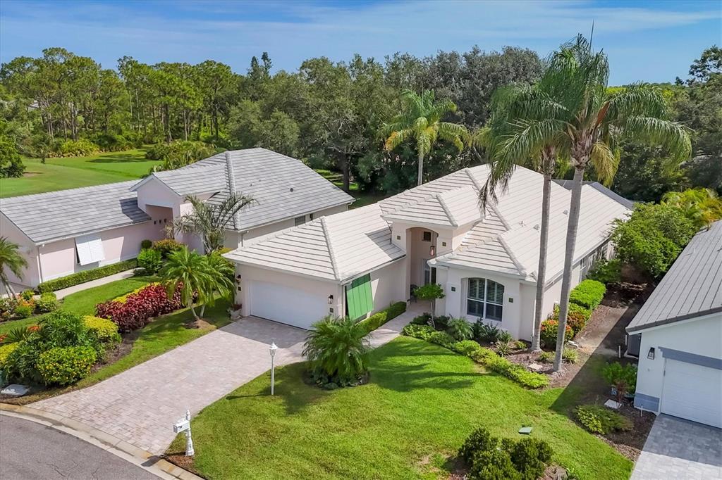 An aerial view shows a single-story house with a light-colored tile roof and driveway — 7916 HAMPTON COURT, UNIVERSITY PARK, FL