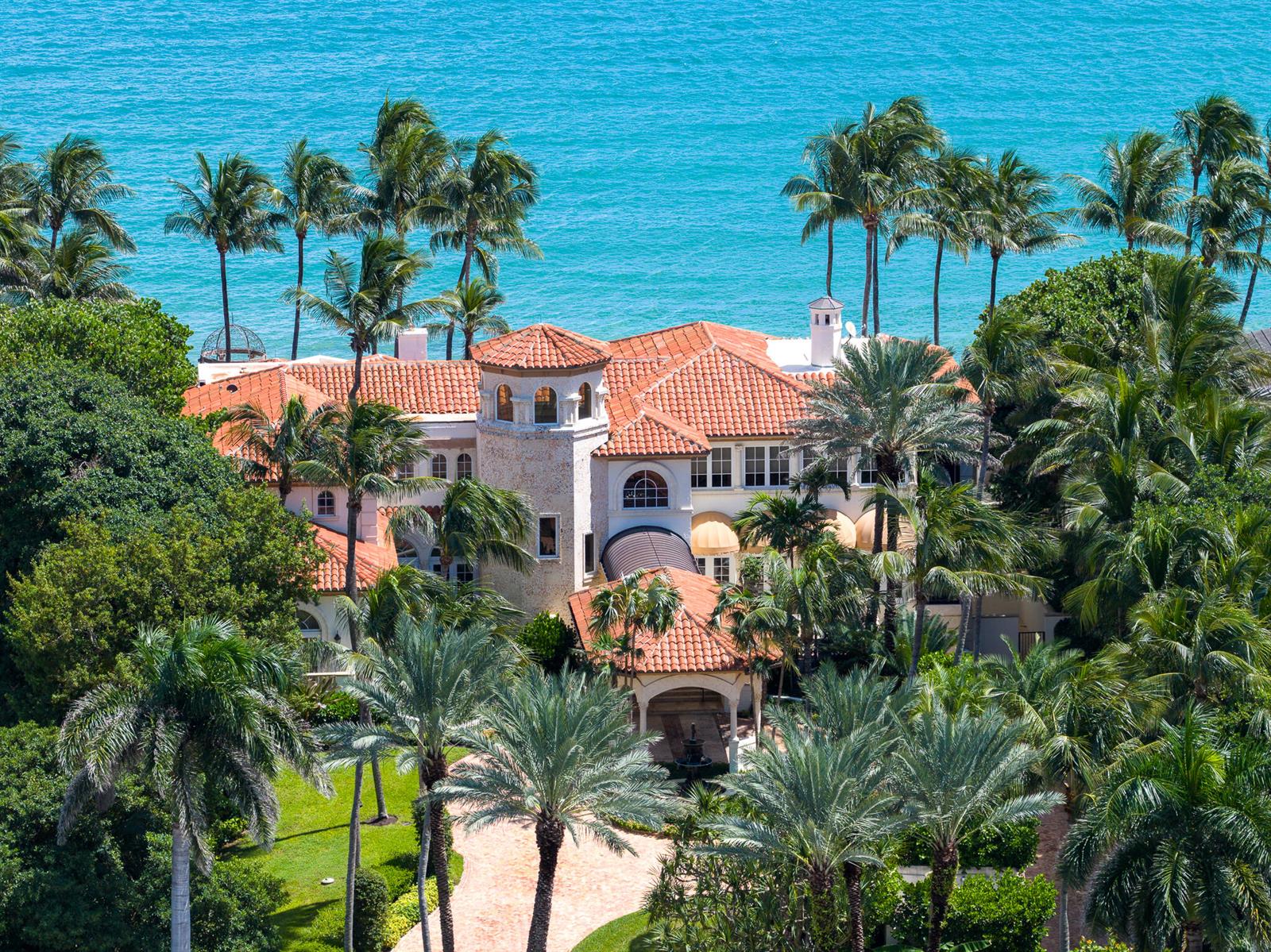 An aerial view of a Mediterranean-style mansion with a red tile roof near the ocean — 6133 N Ocean Boulevard, Ocean Ridge FL 33435, OCEAN RIDGE, FL