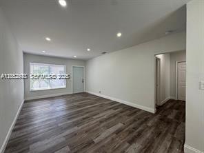 An empty room with light gray walls, recessed lighting, and dark wood-look flooring — 8201 Abbott Ave # 2, Miami Beach FL 33141, MIAMI BEACH, FL
