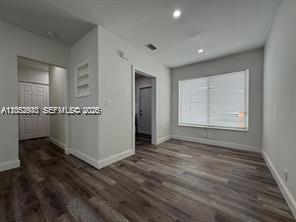 An empty room with light gray walls, wood-look flooring, recessed lighting, and a large window — 8201 Abbott Ave # 2, Miami Beach FL 33141, MIAMI BEACH, FL