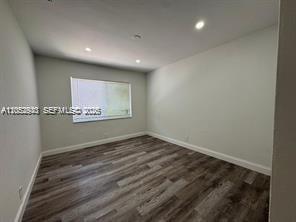 An empty room with light gray walls, recessed ceiling lights, and dark wood-look flooring — 8201 Abbott Ave # 2, Miami Beach FL 33141, MIAMI BEACH, FL