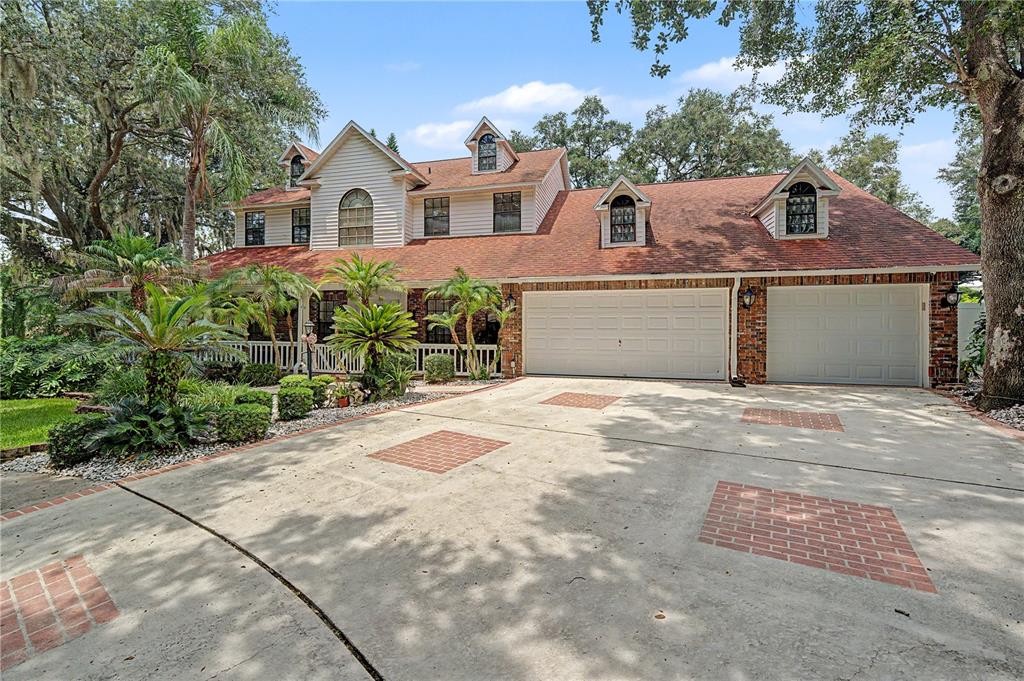 A screened-in swimming pool and spa with a concrete deck and surrounding tropical landscaping — 2004 OAKWOOD KNOLL COURT, VALRICO, FL