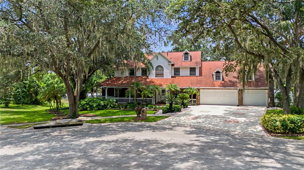 A two-story house with a brick and siding exterior, a three-car garage, and dormer windows — 2004 OAKWOOD KNOLL COURT, VALRICO, FL
