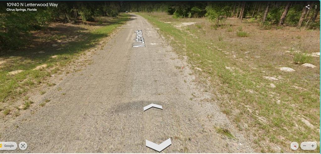 A gravel road stretches through a wooded area in a rural residential neighborhood — 10940 N LETTERWOOD WAY, DUNNELLON, FL