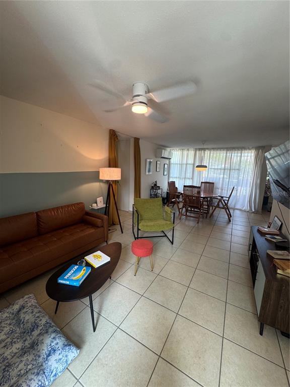 A living room with a brown leather sofa, green armchair, and tile flooring — 400 GRAN BLVD LOS PRADOS UNIT 6-201, CAGUAS, PR