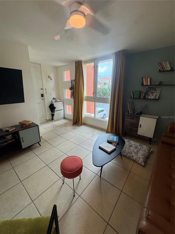 A living room features tiled floors, a ceiling fan, a coffee table, and wall shelving — 400 GRAN BLVD LOS PRADOS UNIT 6-201, CAGUAS, PR