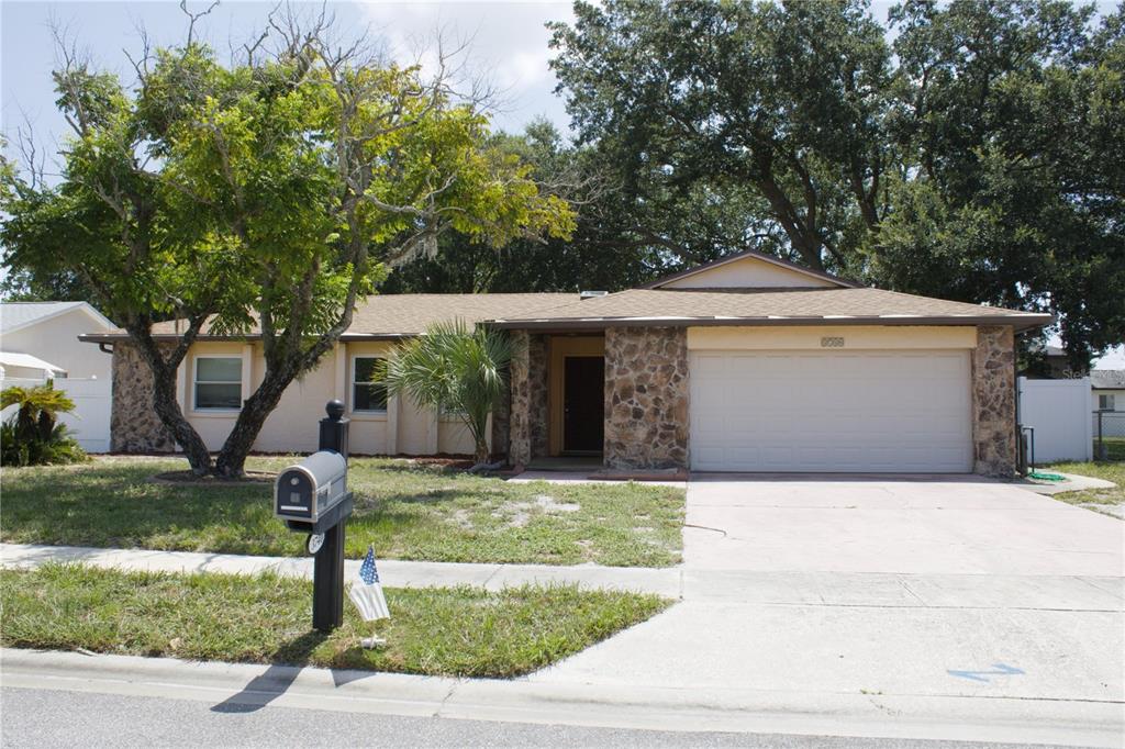 A single-story house with a stone facade, a two-car garage, and a large front tree — 3740 HAWTHORNE LANE, WINTER PARK, FL
