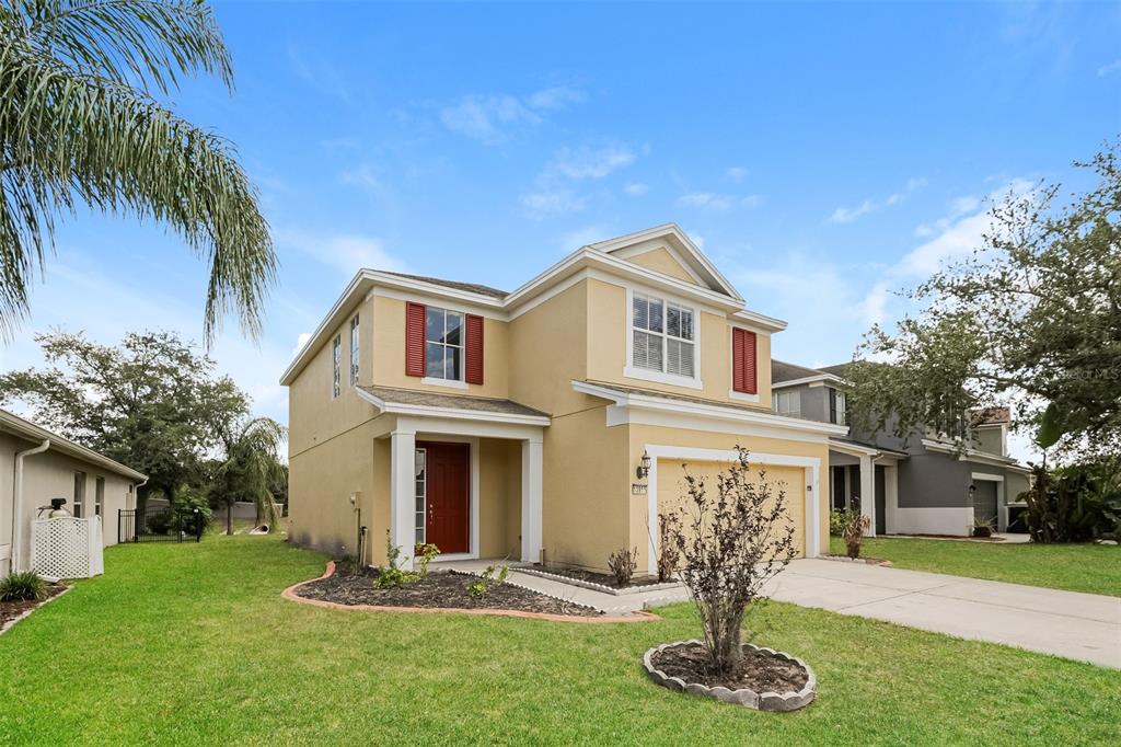A two-story yellow stucco house with a red front door and a two-car garage — 13955 CRATER CIRCLE, HUDSON, FL