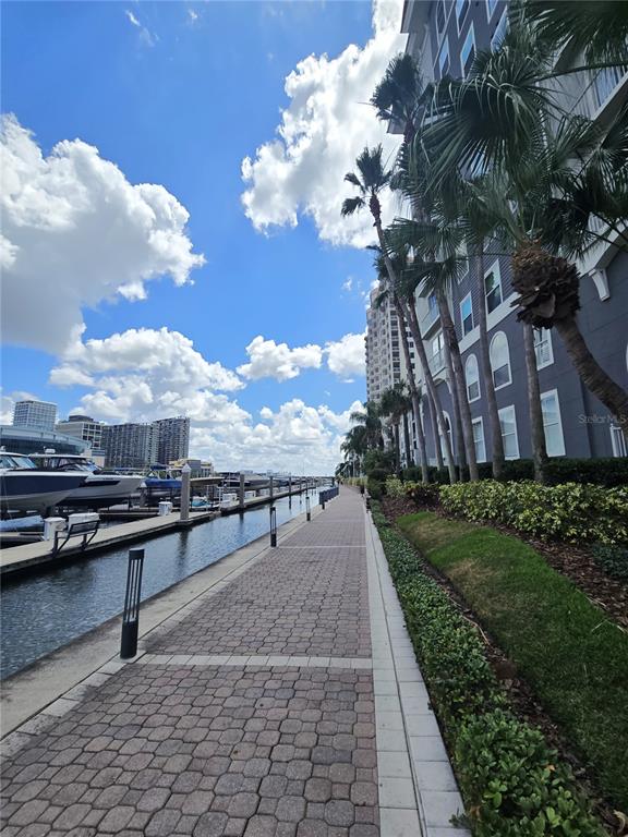 A paved walkway runs alongside a marina with docked boats and a tall apartment building — 700 S HARBOUR ISLAND BOULEVARD UNIT 646, TAMPA, FL