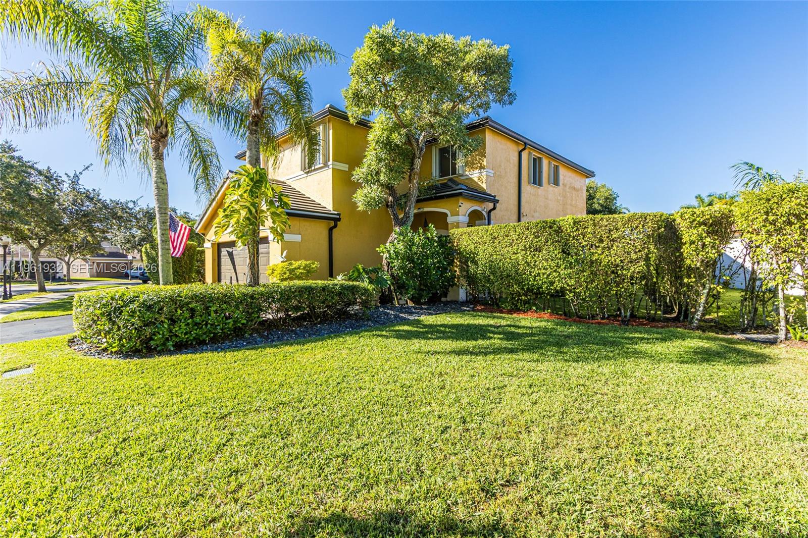 A two-story yellow house with a two-car garage and a manicured hedge — 1280 Majesty Ter, Weston FL 33327, WESTON, FL