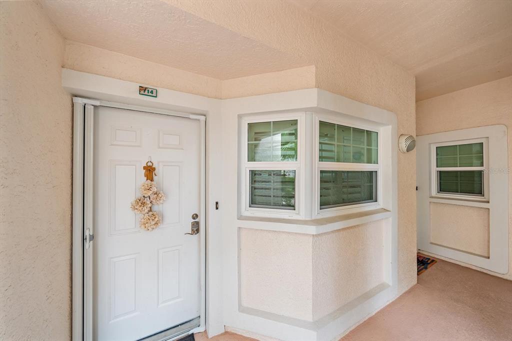 The exterior entrance features a white door with a floral wreath and a bay window — 4244 CENTRAL SARASOTA PARKWAY UNIT 714, SARASOTA, FL