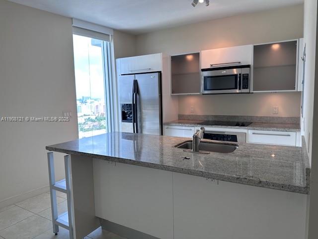 A modern kitchen features white cabinetry, stainless steel appliances, and a granite-topped island — 185 SW 7th St # 2300, Miami FL 33130, MIAMI, FL