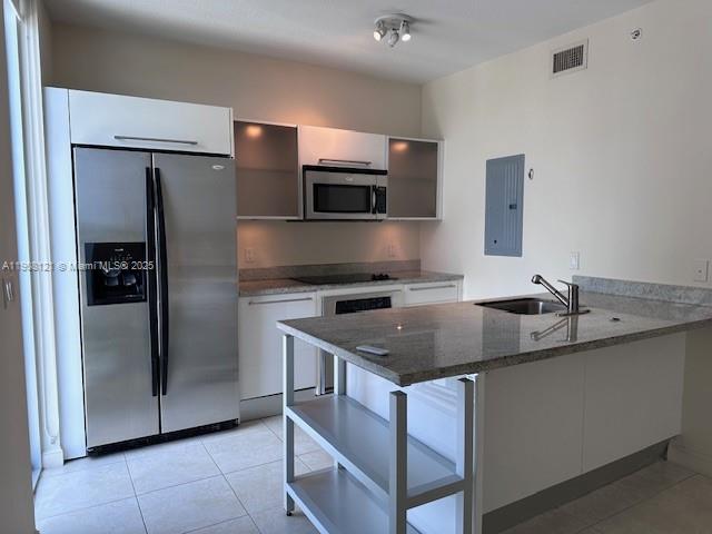 A kitchen features stainless steel appliances, white cabinetry, and a granite-topped island with shelving — 185 SW 7th St # 2300, Miami FL 33130, MIAMI, FL