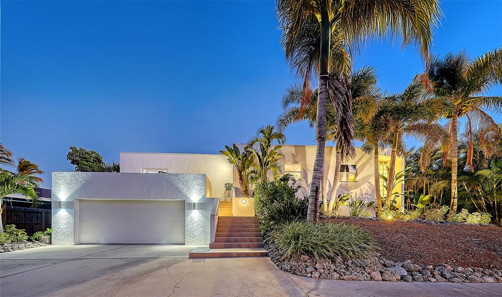 A modern white house with a garage, front stairs, and palm trees at twilight — 1168 WESTWAY DRIVE, SARASOTA, FL