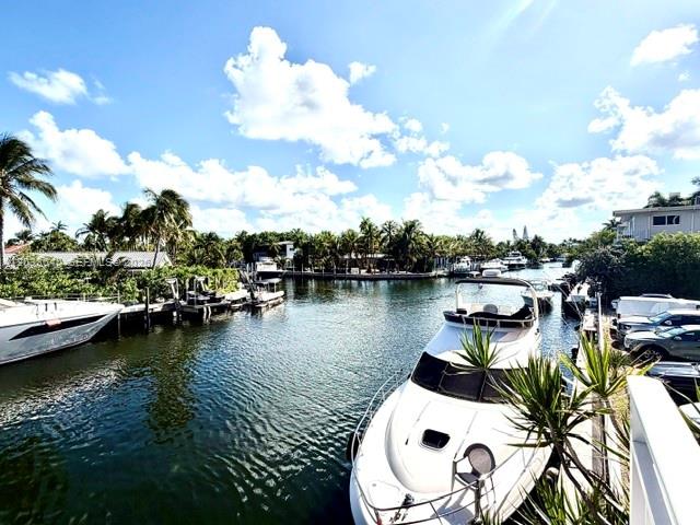 A white yacht is docked in a canal lined with palm trees and houses — 2450 NE 135th St # 704, North Miami FL 33181, NORTH MIAMI, FL