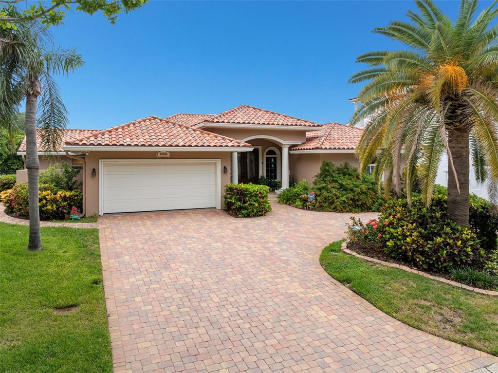 A single-story house with a tiled roof, a two-car garage, and a paved driveway — 2001 ILLINOIS AVE NE, ST PETERSBURG, FL