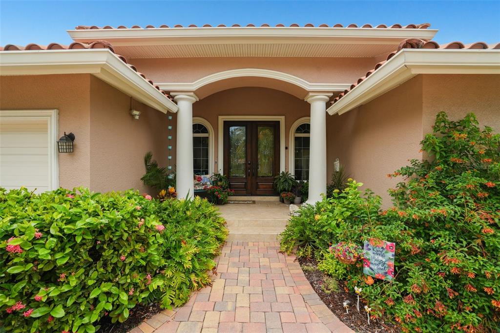 A paved walkway leads to the front entrance of a house with two white columns — 2001 ILLINOIS AVE NE, ST PETERSBURG, FL