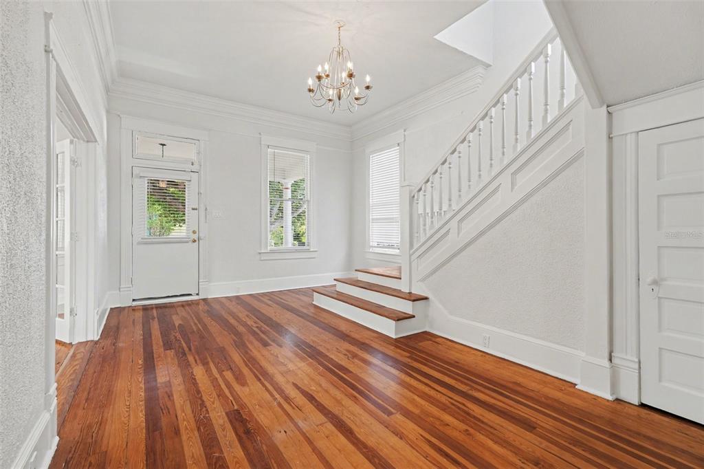 An entryway with hardwood floors, a white staircase, and a chandelier under a high ceiling — 501 W EUCLID AVENUE, TAMPA, FL