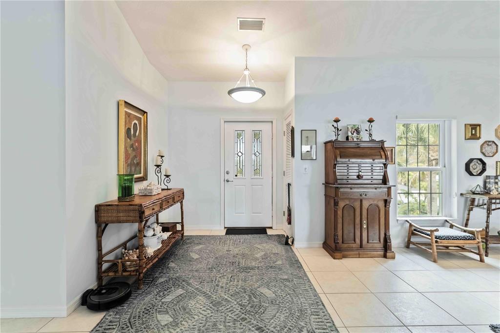 An entryway features a patterned rug, a wooden console table, and a roll-top desk — 7795 MANASOTA KEY ROAD, ENGLEWOOD, FL