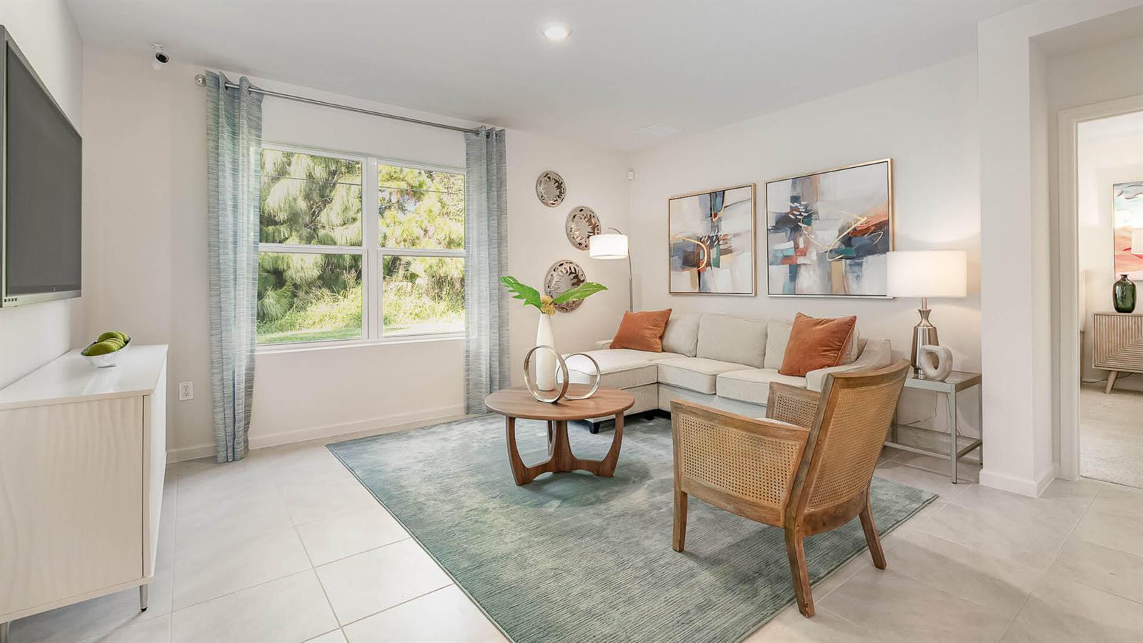 A living room features a sectional sofa, a wooden coffee chair, and a large area rug — 3709 NW 29th Avenue, Okeechobee FL 34972, OKEECHOBEE, FL