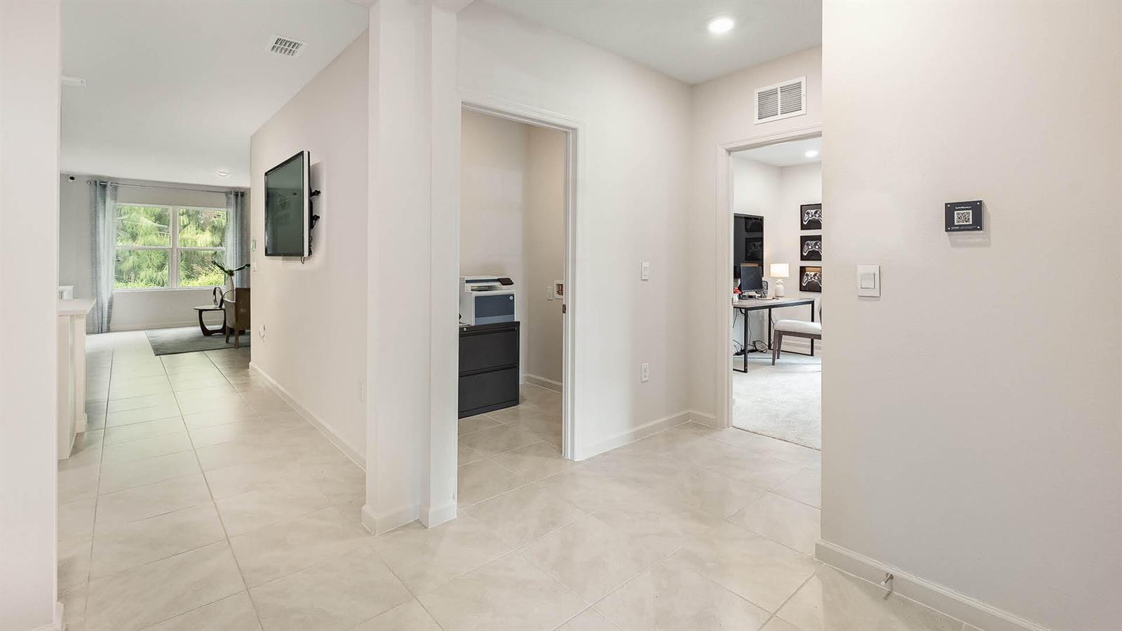 A bright hallway with tile flooring leads to a home office and a living area — 3709 NW 29th Avenue, Okeechobee FL 34972, OKEECHOBEE, FL