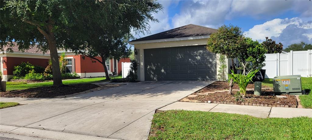A single-story house with a gray garage door and a concrete driveway — 1109 CHINA ASTER WAY, BROOKSVILLE, FL