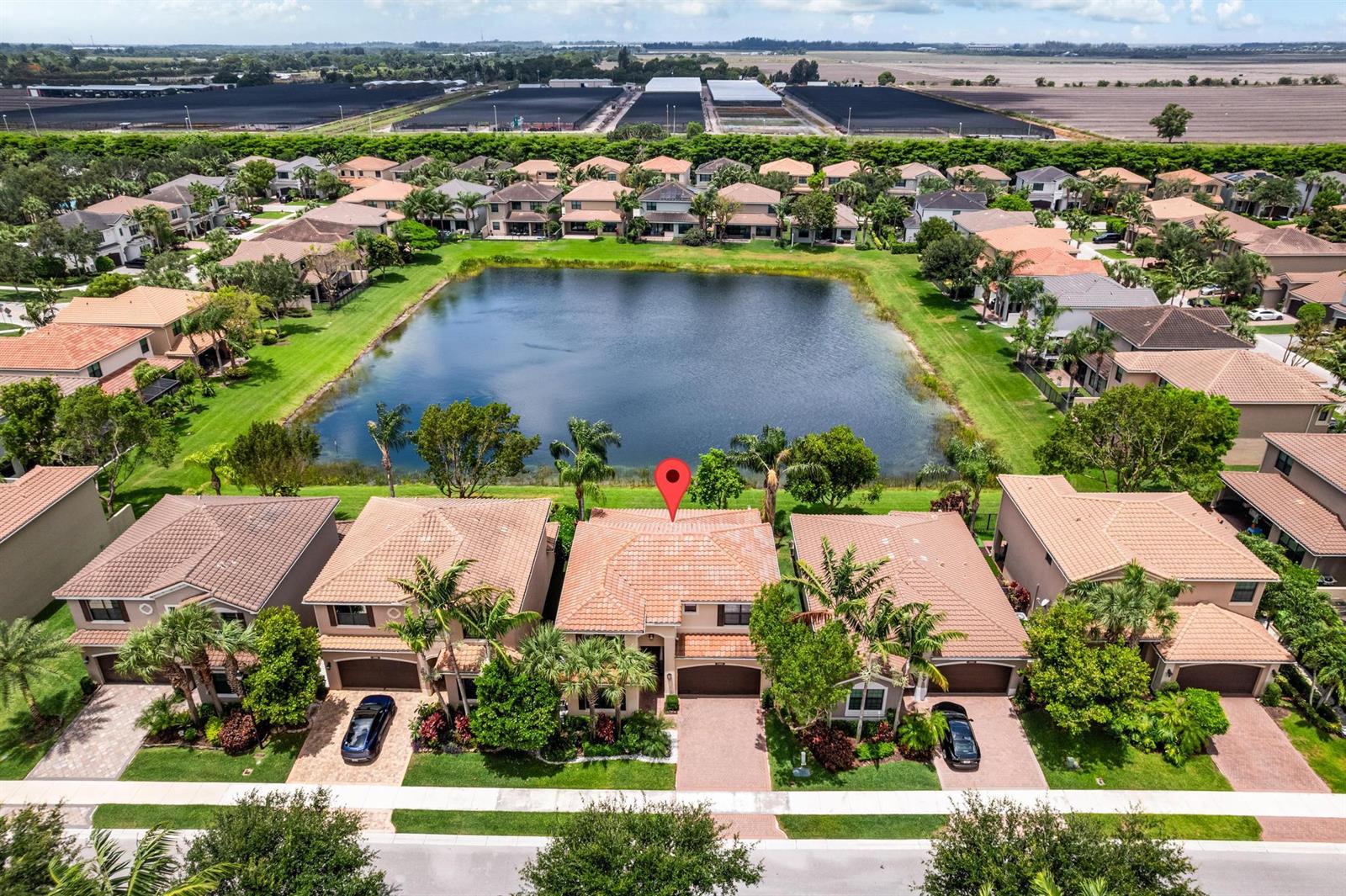 An aerial view shows a row of suburban houses with tile roofs facing a pond — 13809 Imperial Topaz Trail, Delray Beach FL 33446, DELRAY BEACH, FL