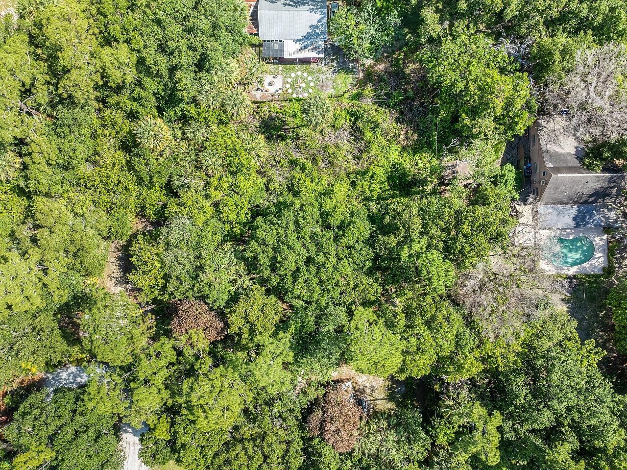 An aerial view shows a wooded lot with two houses and a swimming pool — 564 30th Avenue SW, Vero Beach FL 32968, VERO BEACH, FL