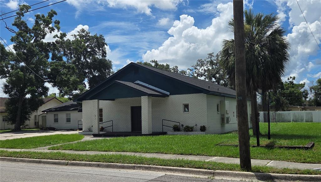A single-story white brick building with a dark roof and a covered front porch — 3103 E LAKE AVENUE, TAMPA, FL