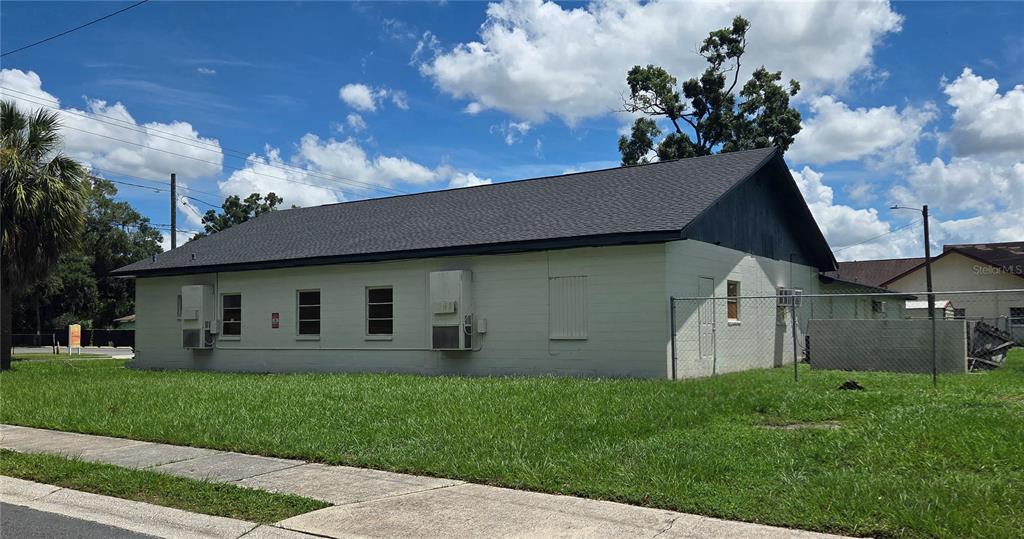 A single-story building with a light-colored concrete block exterior and a dark shingled roof — 3103 E LAKE AVENUE, TAMPA, FL