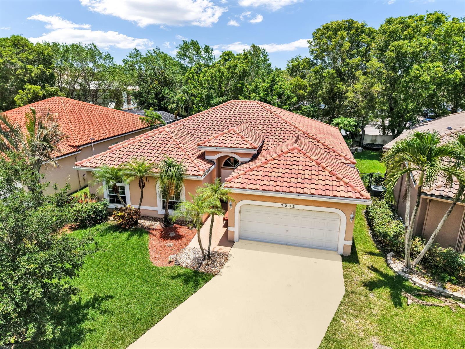 An aerial view of a single-story house with a red tile roof and concrete driveway — 7232 NW 58th Way, Parkland FL 33067, PARKLAND, FL