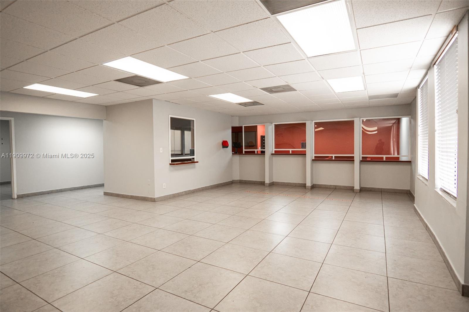 An empty office space features light-colored tile flooring, a drop ceiling, and several interior windows — 1901 SW 1st St, Miami FL 33135, MIAMI, FL