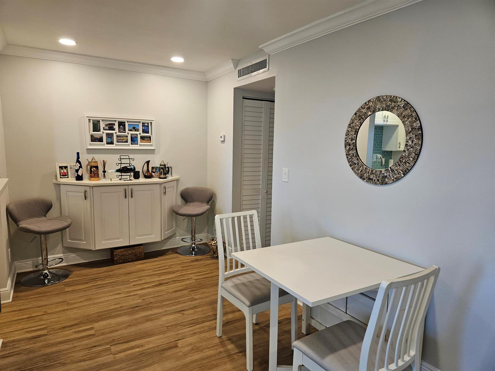 A dining area features a white cabinet, two bar stools, and a small table — 3170 Holiday Springs Boulevard # 310, Margate FL 33063, MARGATE, FL