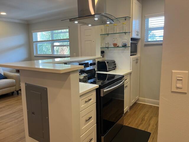 A kitchen features a stainless steel range, a range hood, and white cabinetry — 3170 Holiday Springs Boulevard # 310, Margate FL 33063, MARGATE, FL