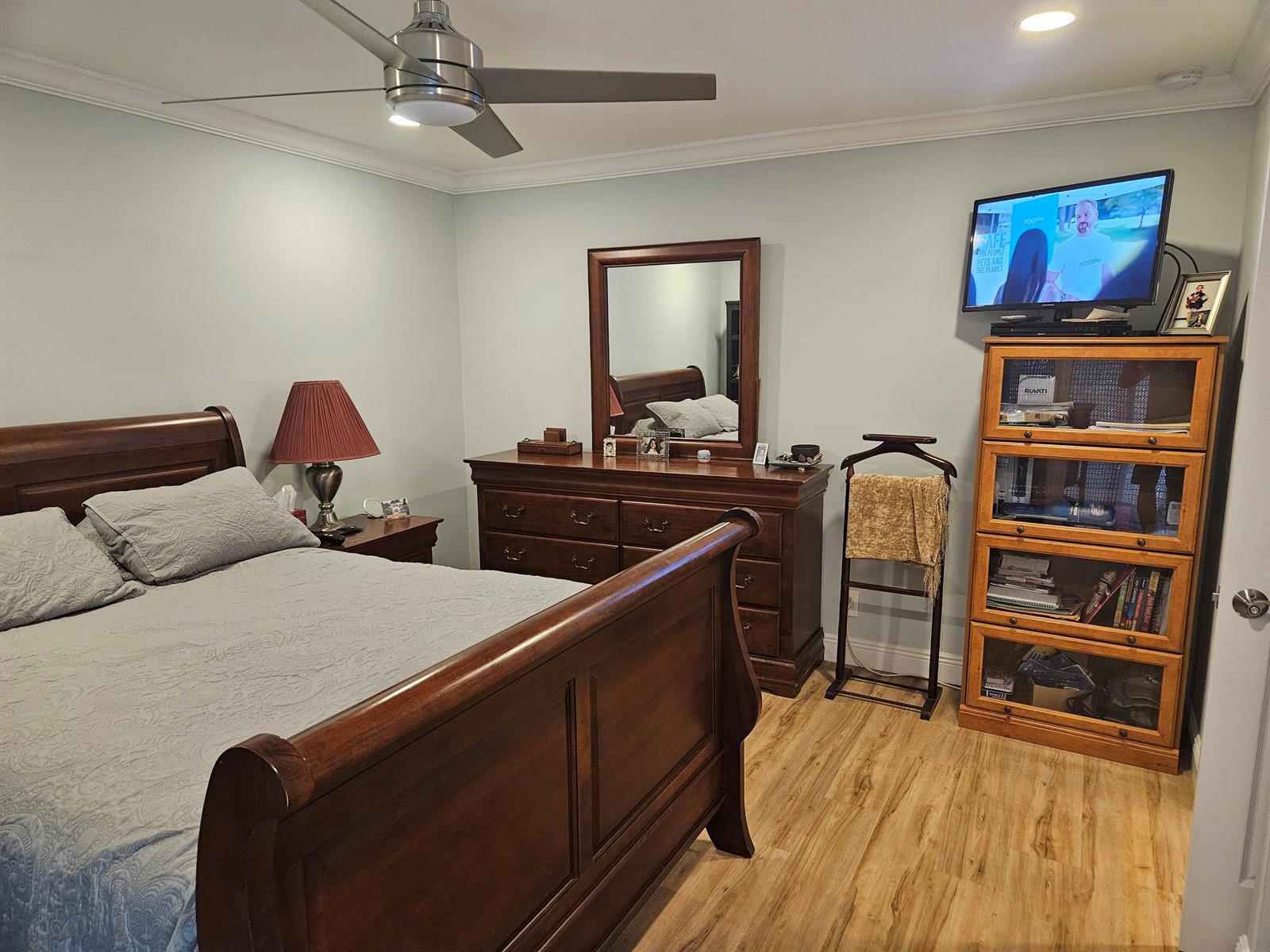A bedroom features a wooden sleigh bed, a dresser with a mirror, and a television stand — 3170 Holiday Springs Boulevard # 310, Margate FL 33063, MARGATE, FL